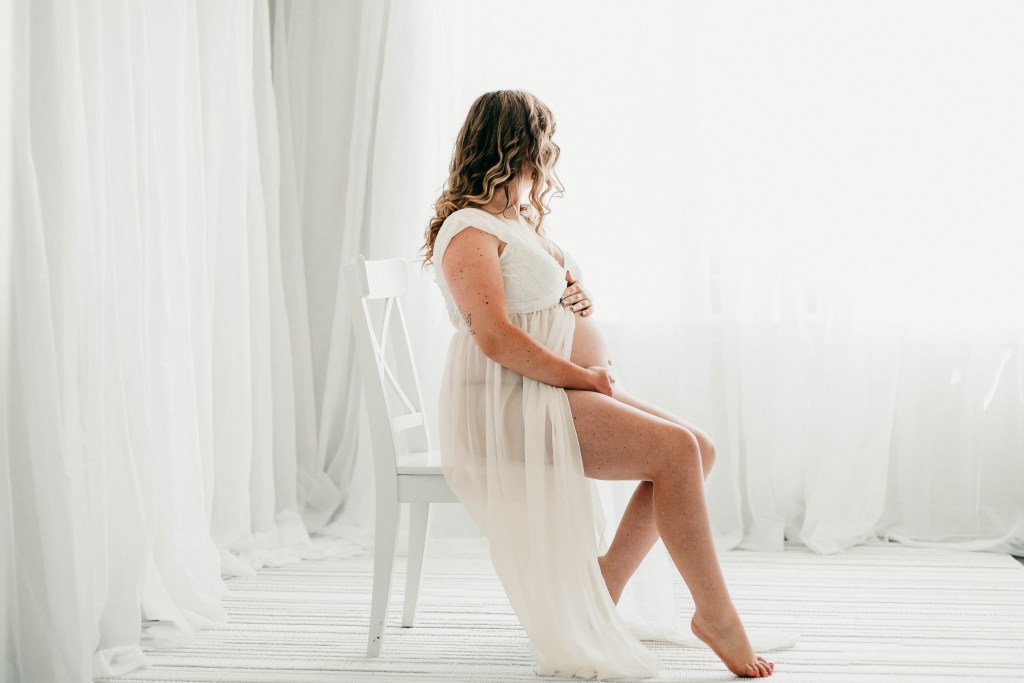 a pregnant woman sitting on a chair during her maternity session in eugene oregon for Heidi Rakas photography