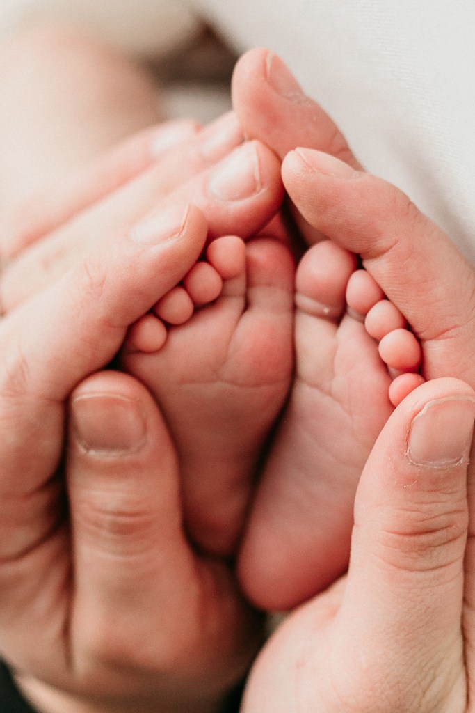 Close-up of a newborn’s tiny hands and feet, capturing delicate details in soft, natural light.