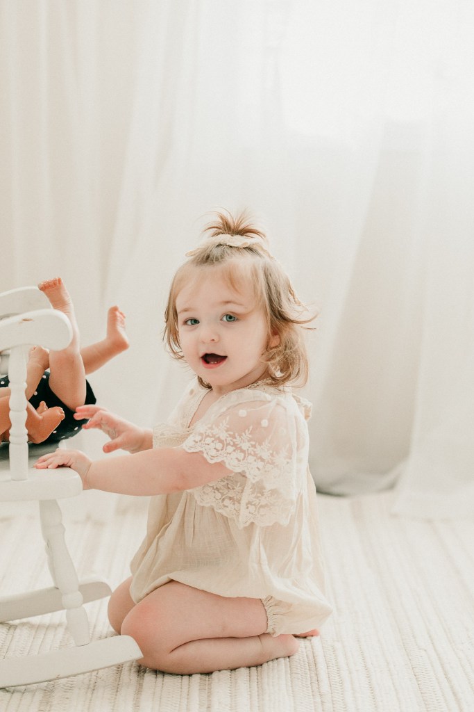 a toddler playing with her baby doll in Eugene Oregon photography studio
